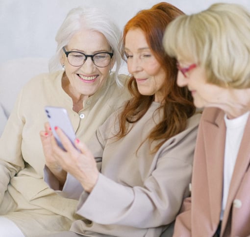 Group of three women videocalling using a phone